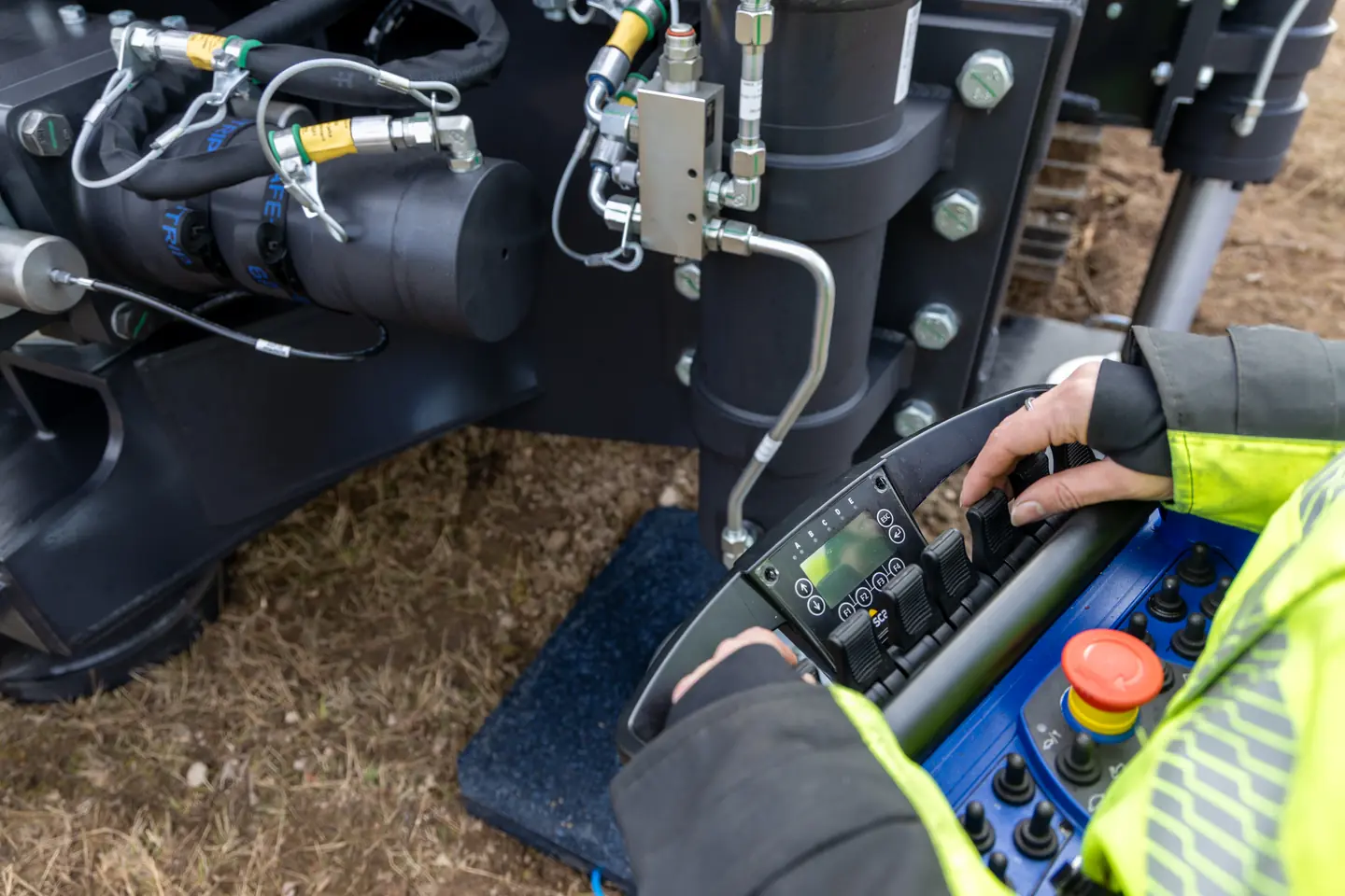 An operator using the handheld controller beside the rig.