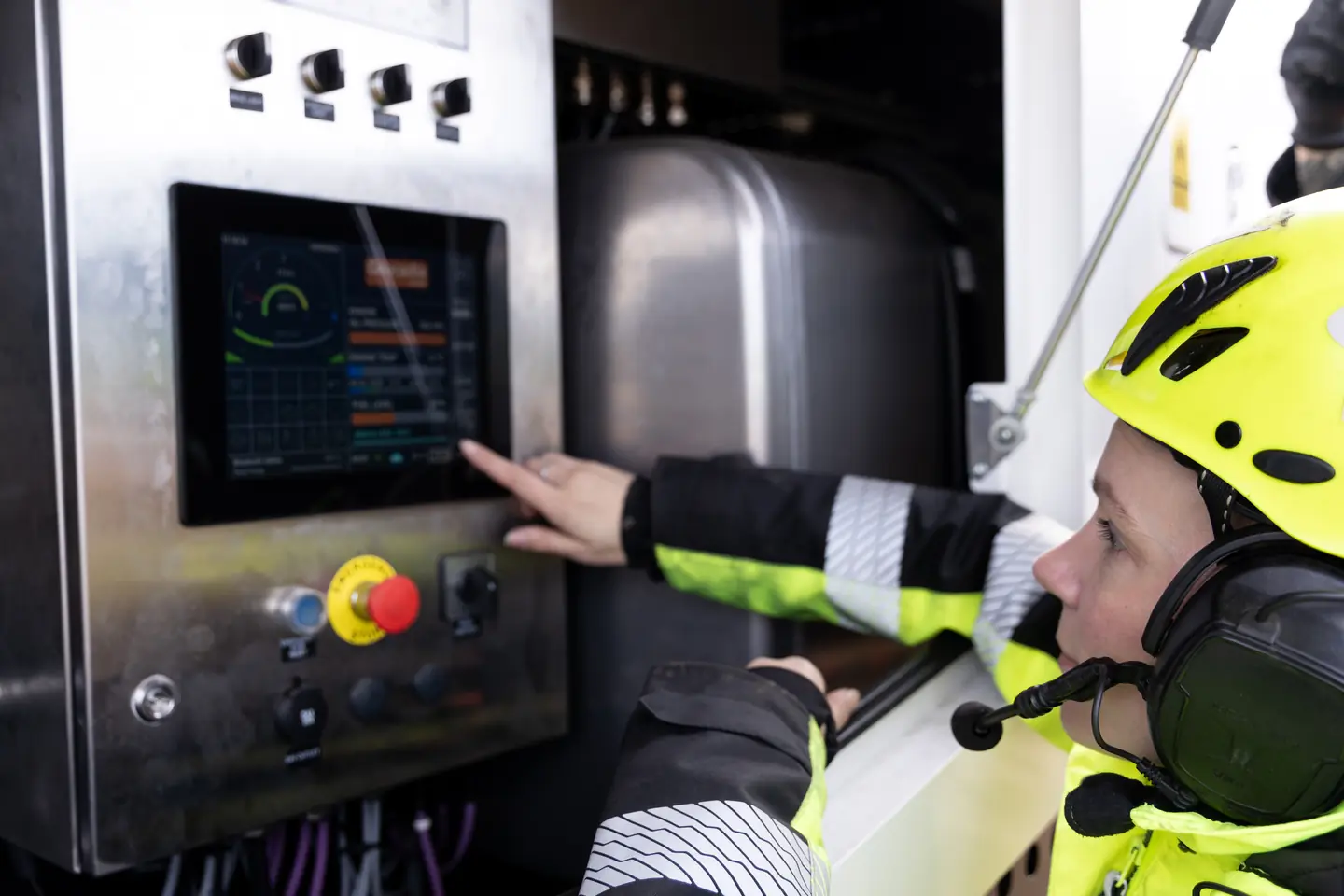 An operator using the rig's touchscreen control panel.