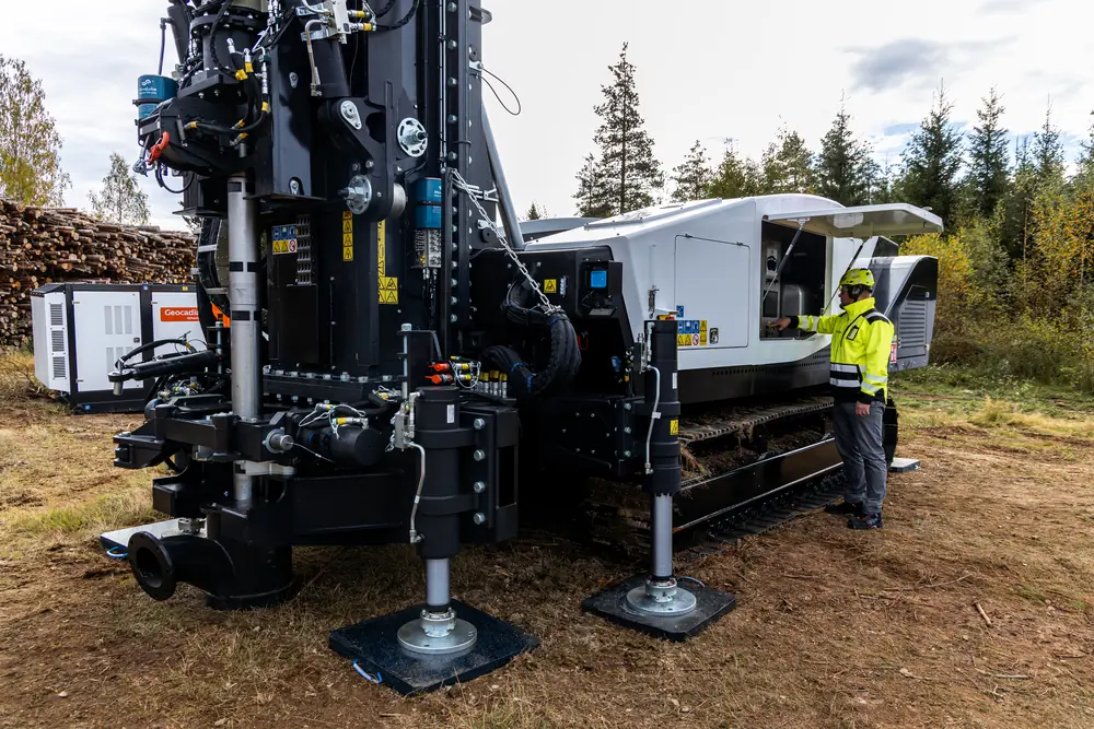 An operator beside the rig base and stabiliser feet.
