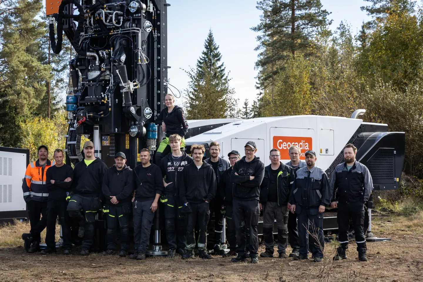 A group photographed beside the Geocadia-branded GM2000.